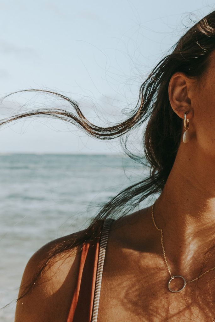 wind blows model's hair so you can see her earring